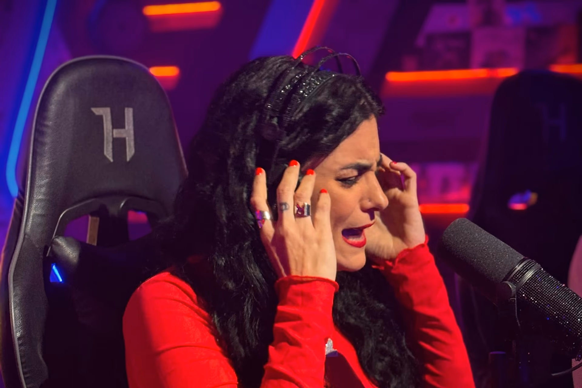 Laura Santos cantando con auriculares ante el micrófono en un estudio de radio